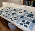 Hand basting the quilt layers